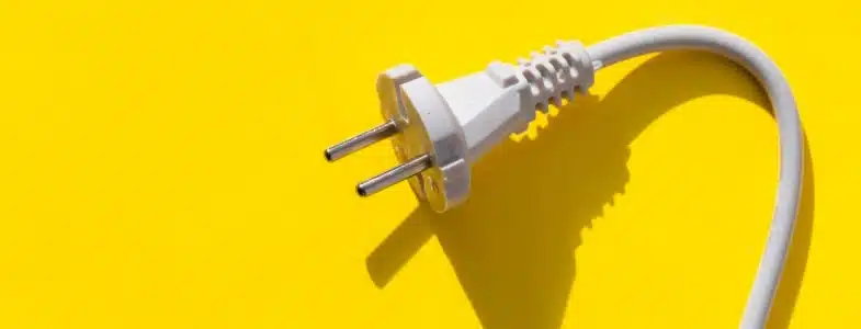 Prise électrique blanche sur fond jaune vibrant